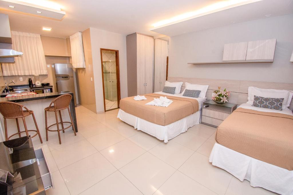 a large room with two beds and a kitchen at Residencial BoaVida in Fortaleza