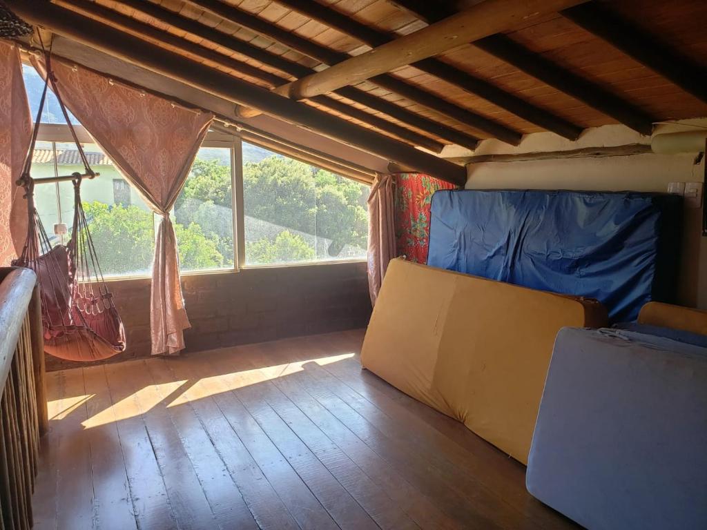 a room with a bed and a window with a hammock at Casa do Rogério in Santana do Riacho