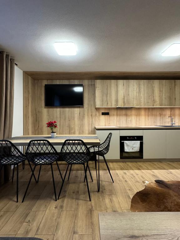 Il comprend une cuisine avec une table et des chaises ainsi qu'une télévision. dans l'établissement Drevenica Skye Terchová, à Terchová