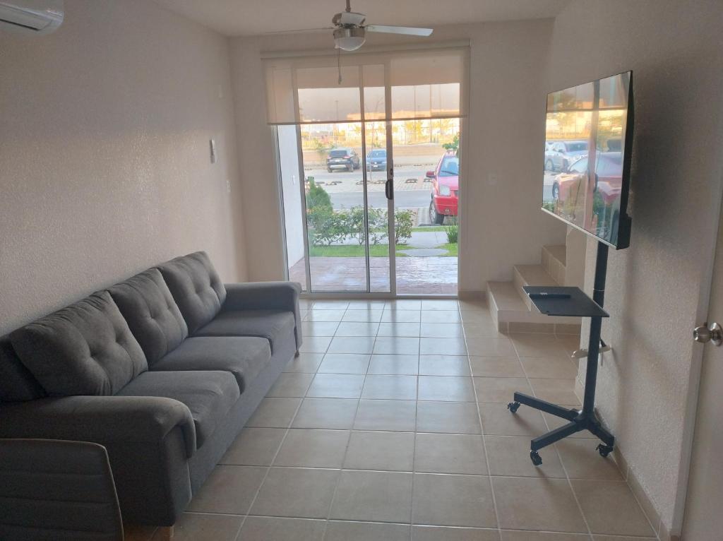 sala de estar con sofá y TV en Casa de descanso en residencial, en Tlayecac
