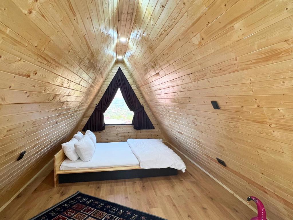 Cama pequeña en habitación de madera con ventana en Kartepe Vista Bungalov, en Kartepe
