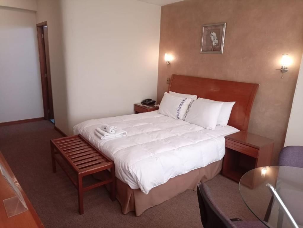 um quarto de hotel com uma cama e uma mesa em Eurotel Davina em La Paz