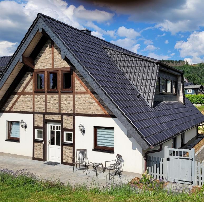 ein Haus mit einem Dach aus Sonnenkollektoren darauf in der Unterkunft Ferienhaus Naturregion Sieg bis 6 Personen in Windeck