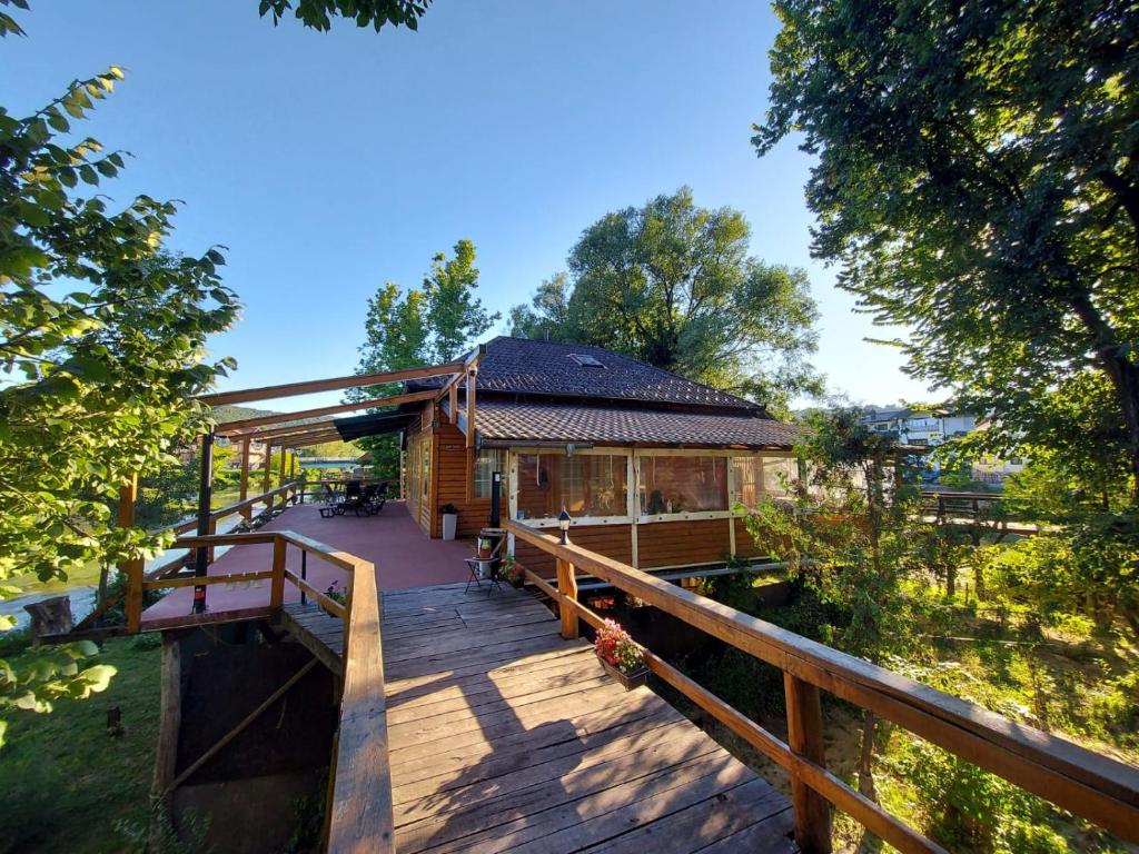 a log cabin with a wooden walkway leading to it at Haus Palazzo in Bosanska Krupa