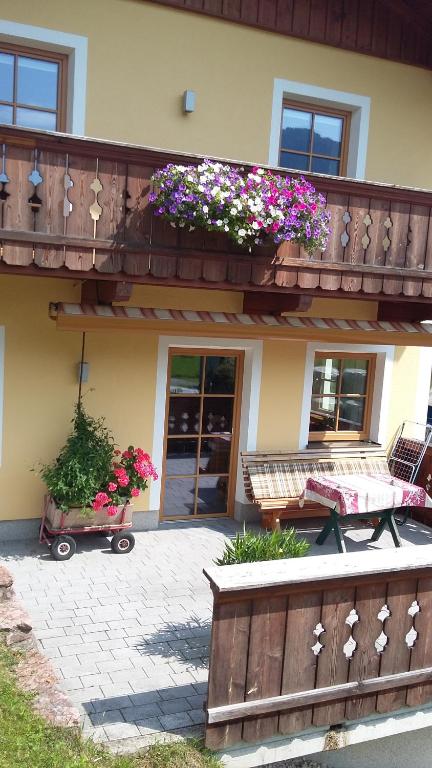 una casa con un balcón con flores. en Ferienhaus Brennerbauer, en Lofer