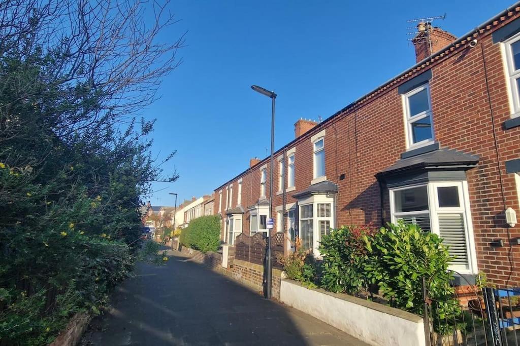 an empty street with brick houses on the side at Lovely 3 bedroom Whitley Bay Townhouse. in Whitley Bay