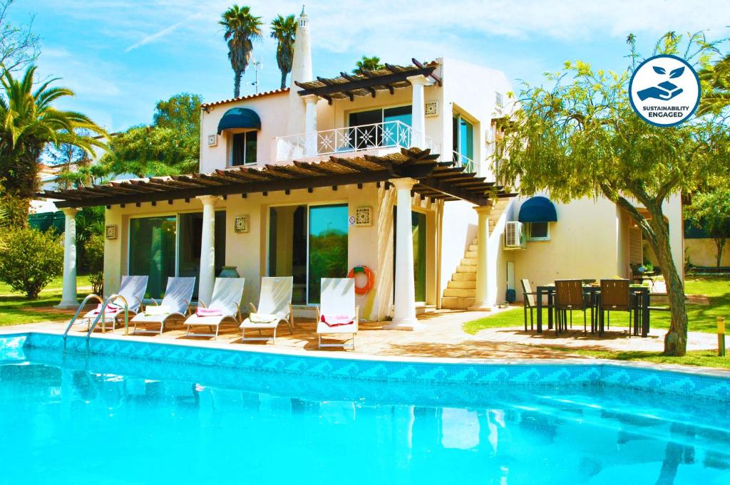 a villa with a swimming pool in front of a house at Villa Bogota by Algarve Vacation in Albufeira