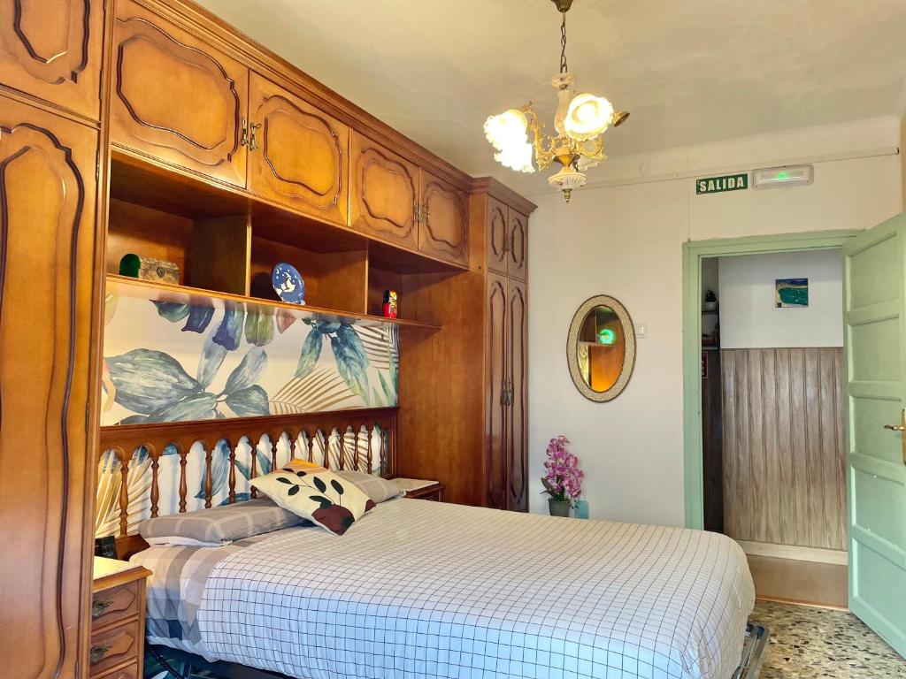 Schlafzimmer mit einem großen Bett mit einem Kopfteil aus Holz in der Unterkunft Casa Rural in Valtierra