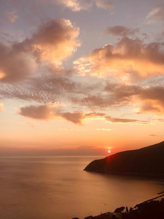a sunset over the ocean with the sun setting at Appartamento Moneglia Holidays in Moneglia