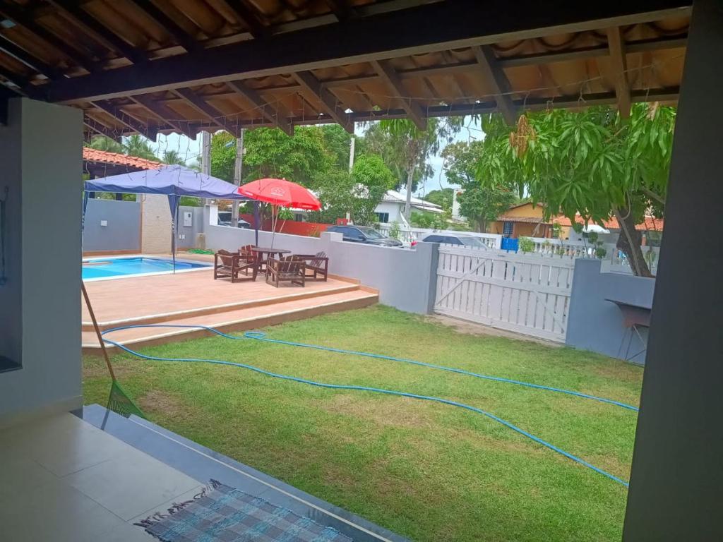 um quintal com uma piscina e uma mangueira em Casa da Mari em Vera Cruz de Itaparica
