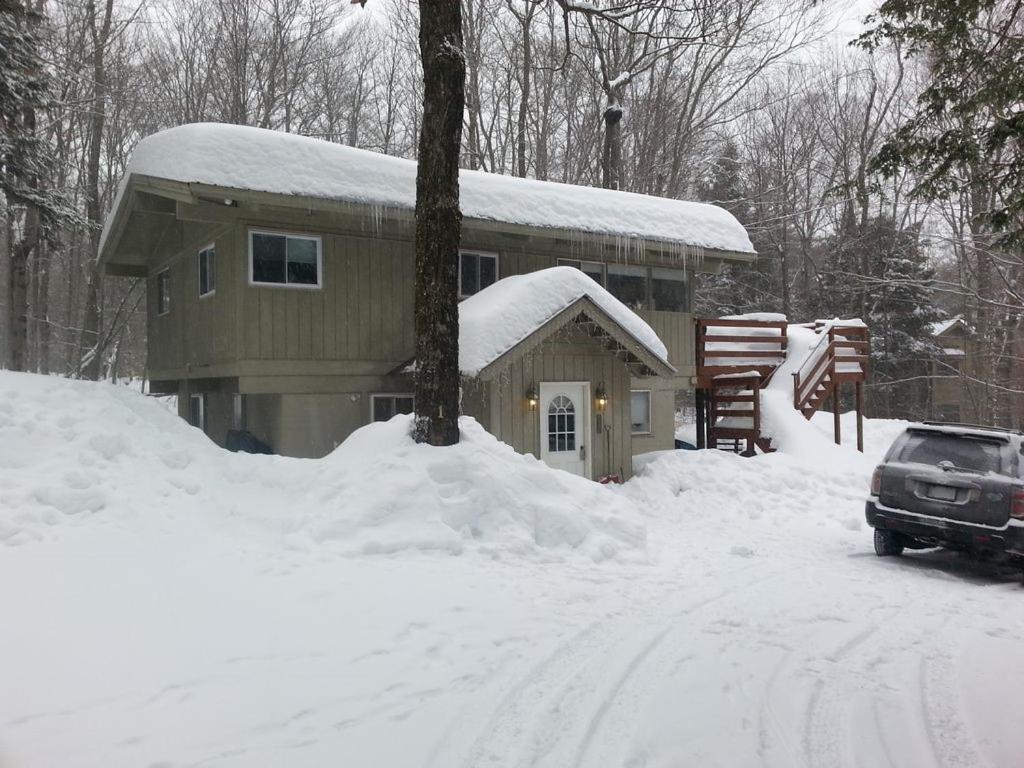 a house with a car parked in the snow at The Last Run - 4BR Chalet between Mt. Snow & Stratton in Wardsboro