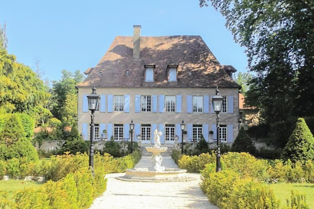 una gran casa blanca con una fuente frente a ella en Domaine de La Barde guest rooms and suites., en Le Bugue