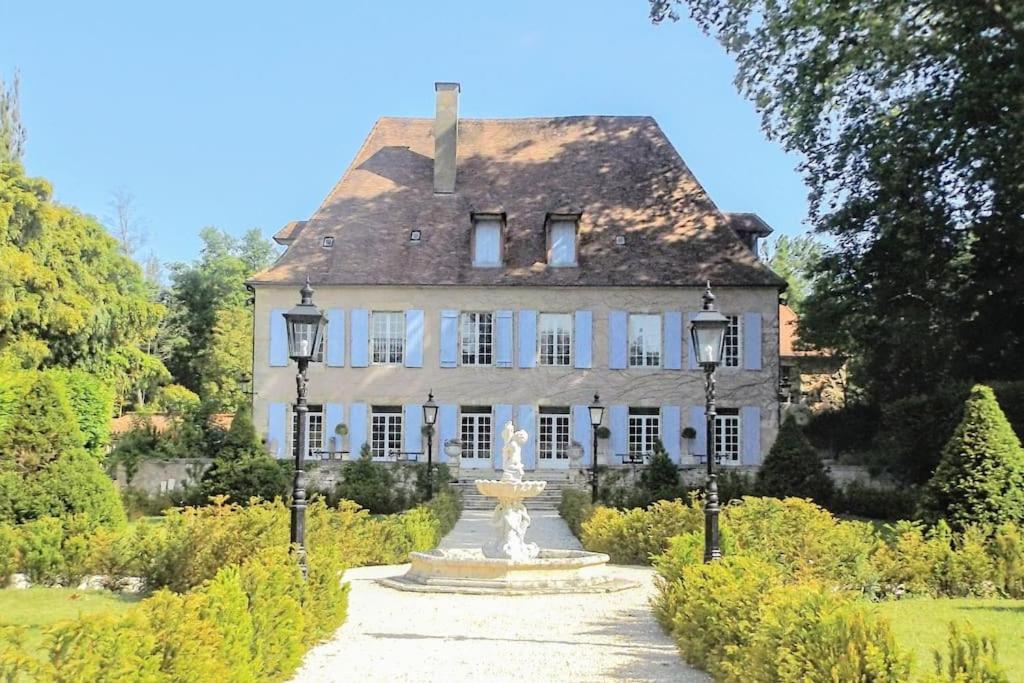 Une grande maison blanche avec une fontaine en face de celle-ci dans l'établissement Domaine de La Barde guest rooms and suites., au Bugue