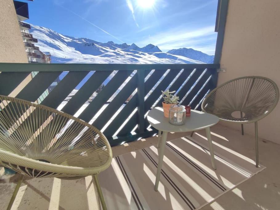 balcone con 2 sedie, tavolo e montagne di Cocon Montagnard avec Terrasse et vue Panoramique a Germ