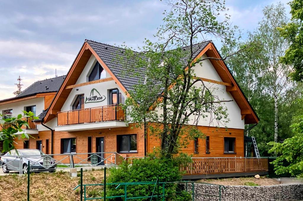 une grande maison avec un toit en gambrel dans l'établissement Vila DEDO, à Tatranská Lomnica