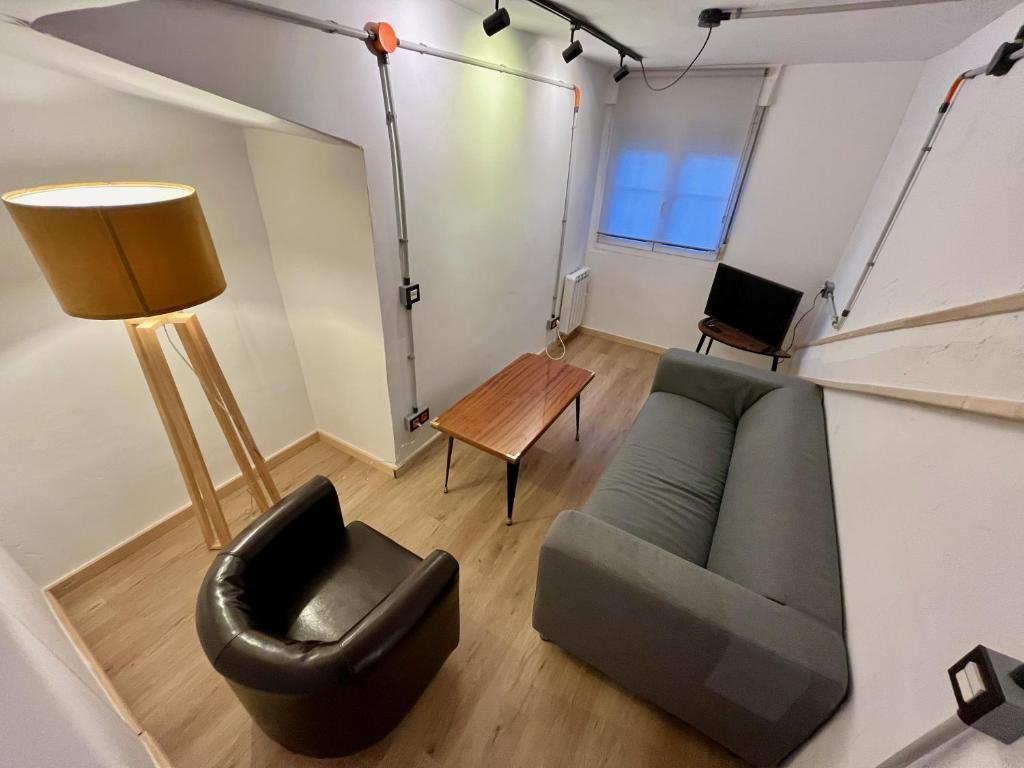 uma sala de estar com um sofá e uma cadeira em Loft Villaviciosa em Villaviciosa