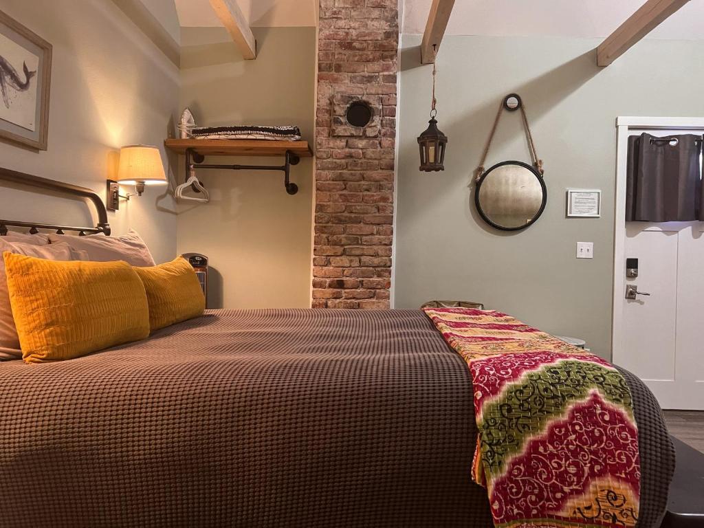 a bedroom with a bed and a brick wall at Sea Glass Inn in Seaside