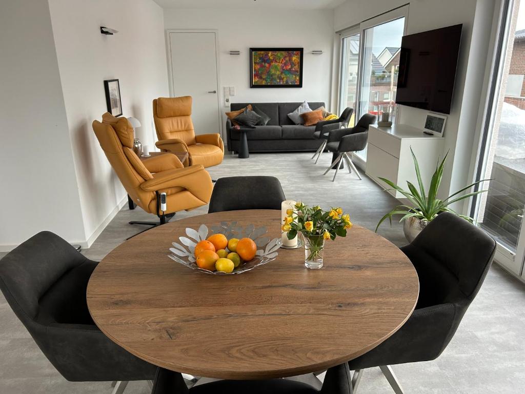 a table with a bowl of fruit on it in a living room at Penthouse Jever - großzügige Dachterrasse in Jever
