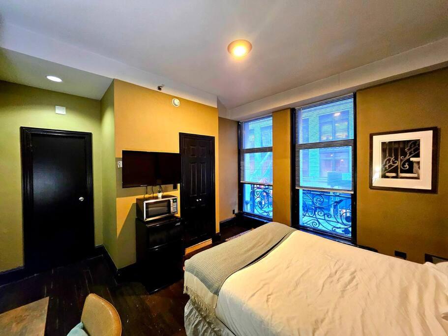 um quarto com uma cama e uma televisão e duas janelas em Hotel-Studio @ The Mansfield Midtown em Nova York