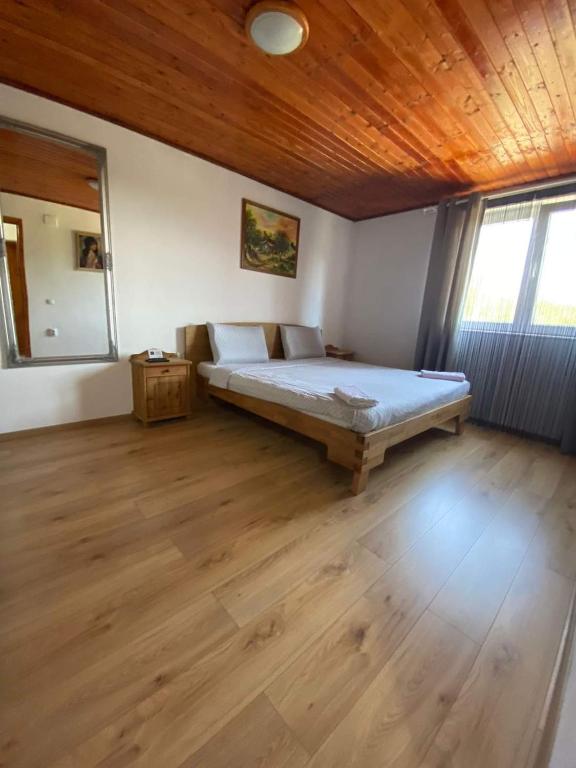 a bedroom with a bed and a wooden ceiling at Casa Nicolae in Silvaşu de Sus