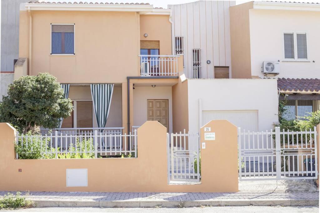 uma casa com uma cerca branca em frente em Posidonia Guest House La Caletta Sardegna em La Caletta