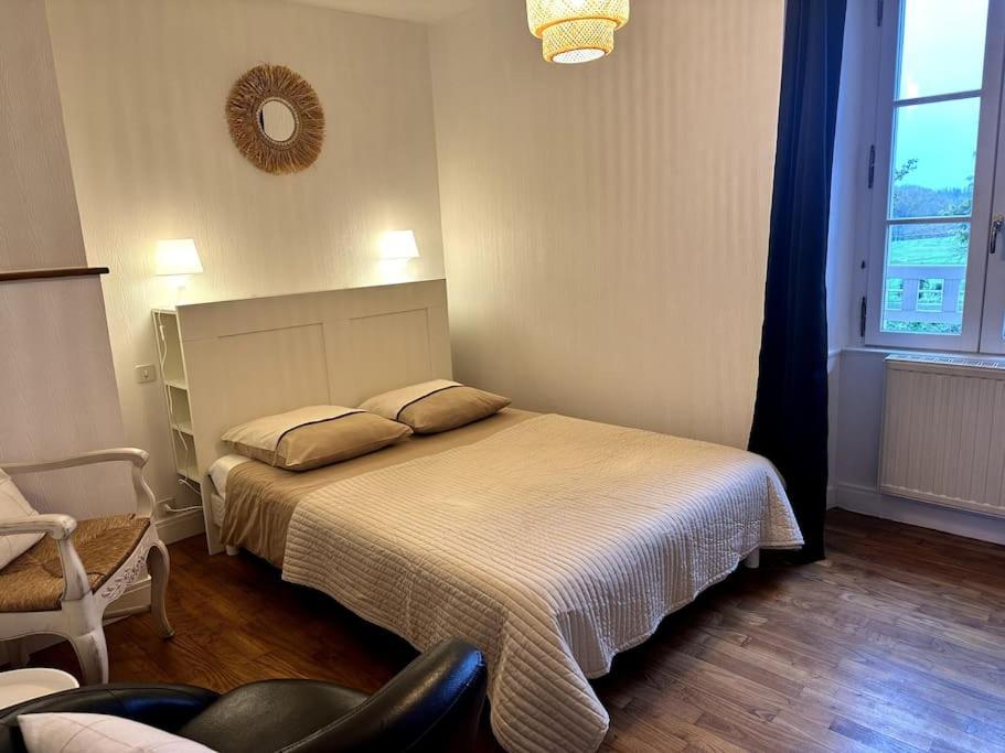 a bedroom with a bed and a chair and a window at Appartement rénové entre Saint-Malo et le Mont-Saint-Michel in Dol-de-Bretagne