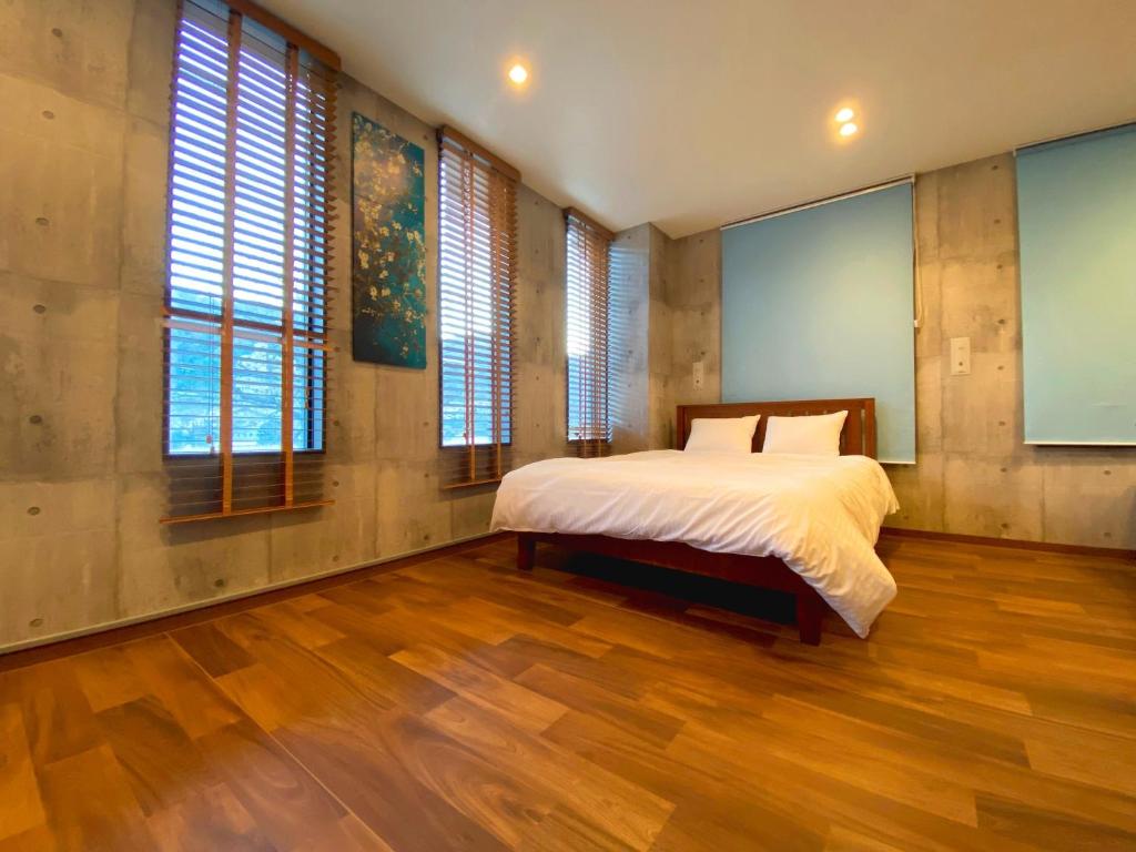 Mongawa的住宿－Sakuraya Ryokan - Vacation STAY 51095v，卧室配有一张床、木地板和窗户。