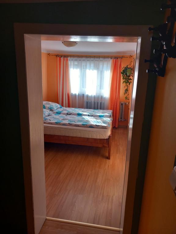 a small bedroom with a bed and a window at Apartamenty pod Rykowiskiem in Korbielów