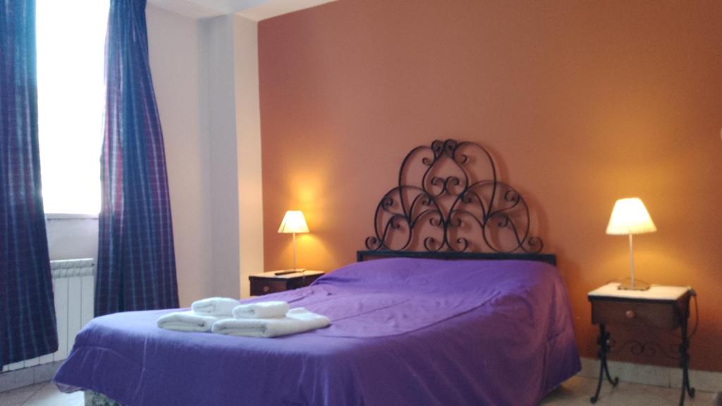 um quarto com uma cama roxa com toalhas em Hotel Nuevo CASABLANCA em Salta