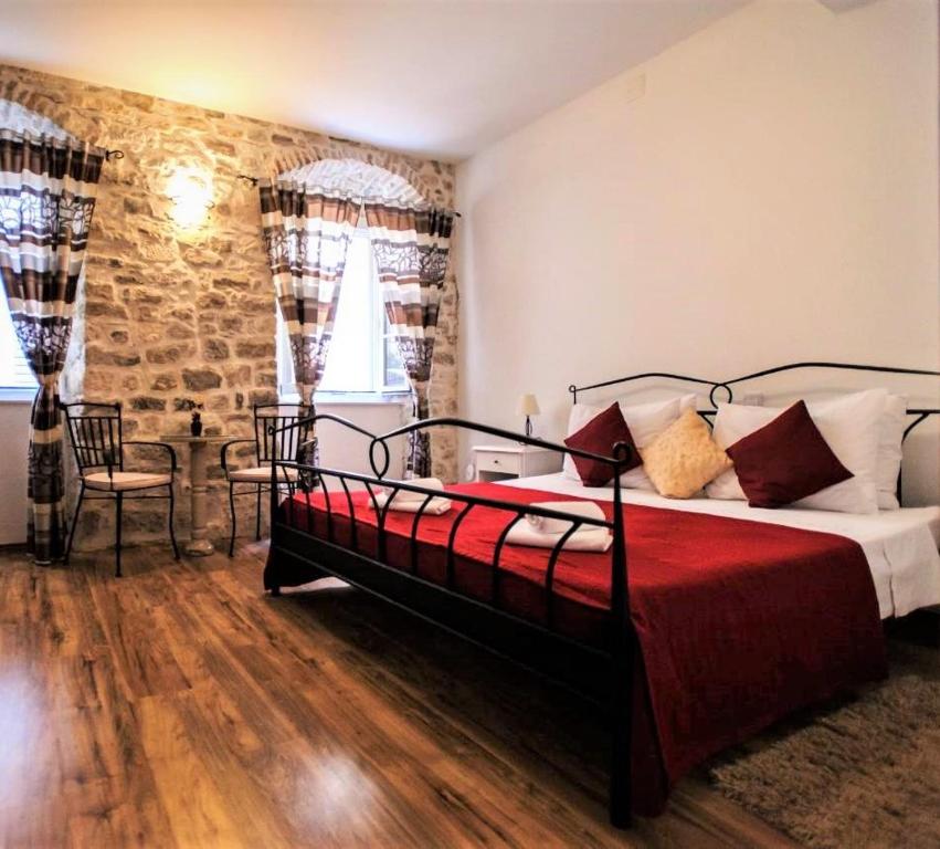 a bedroom with a large bed with a red blanket at Grand Bedroom Aptm Palace Top Location in Split