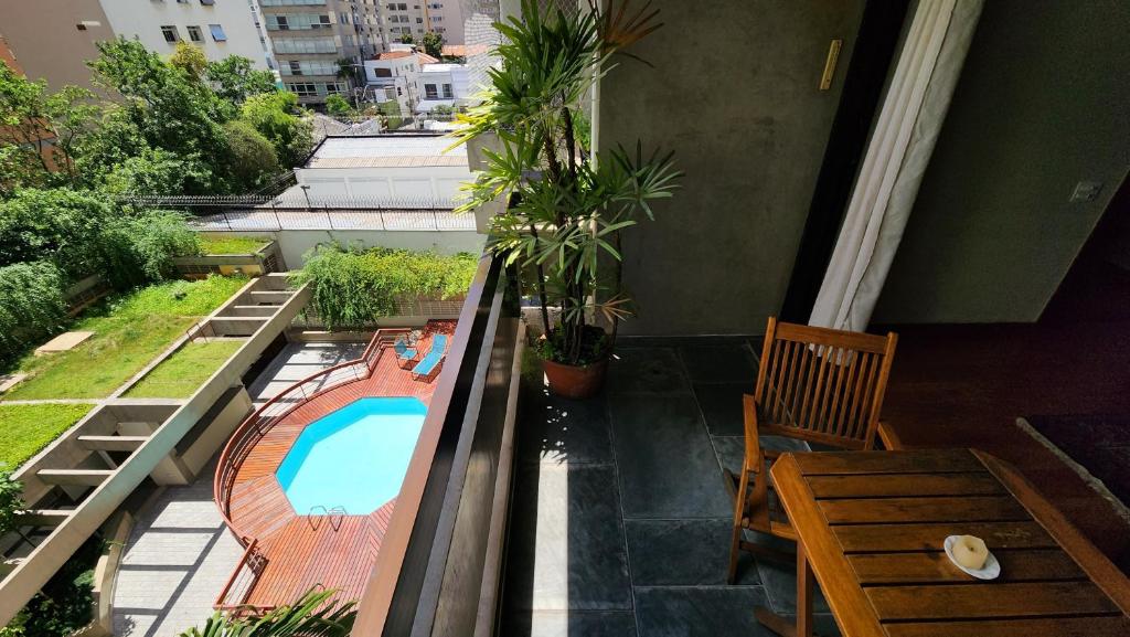 a balcony with a swimming pool and a table and chairs at Lorena Residence - Cozy Flat with Balcony in São Paulo