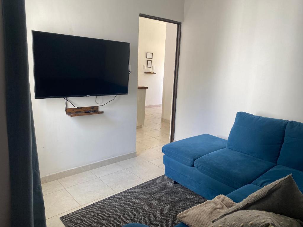 シウダー・バージェスにあるCasa Orizabaのリビングルーム(青いソファ、薄型テレビ付)
