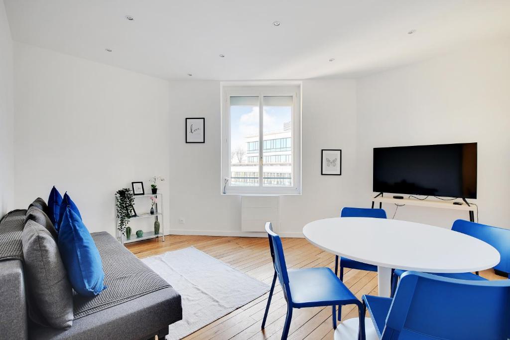 sala de estar con sofá y mesa en Appartement Refait À neuf 4 Couchages, en Levallois-Perret