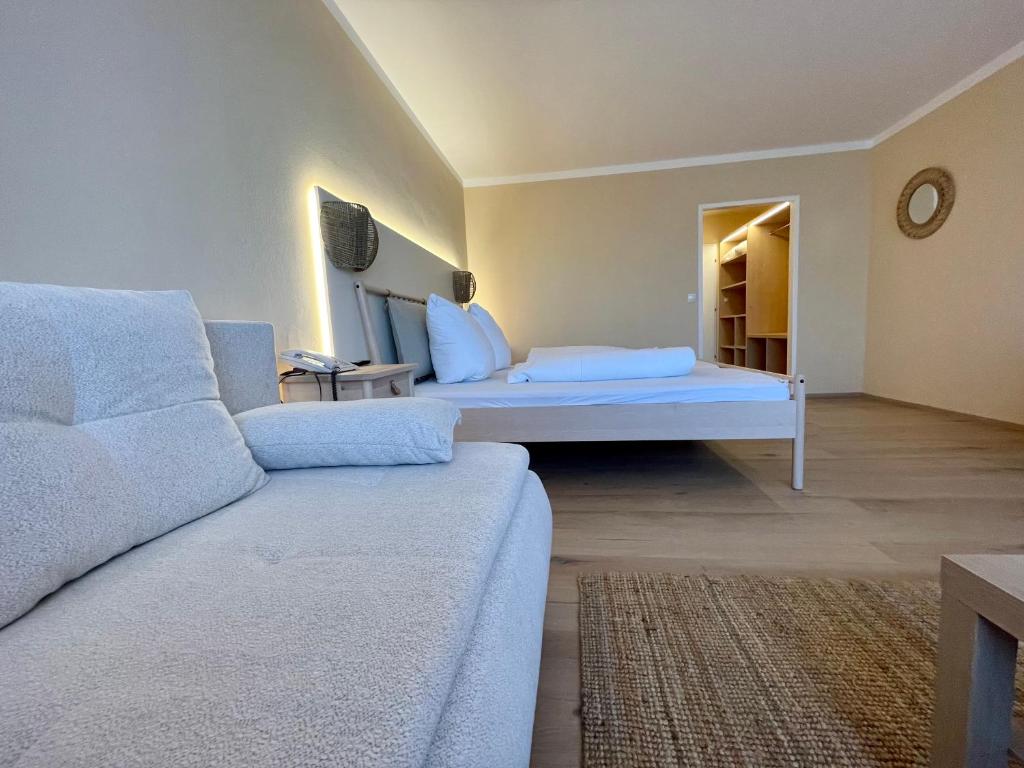 sala de estar con cama y sofá en Hotel Berghof Graml en Hallwang