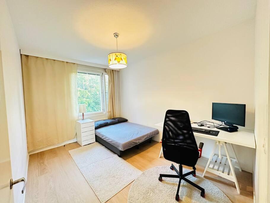 a bedroom with a desk and a bed with a computer at Relax Convenient Transit Stays -shared apartment in Vantaa