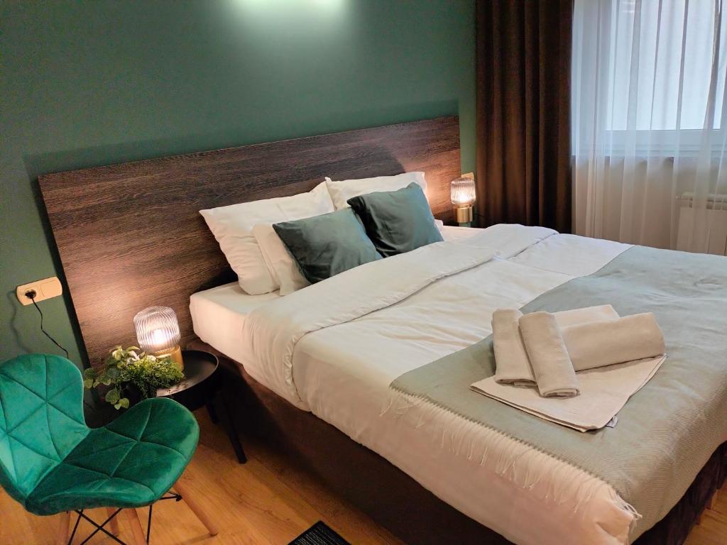 オストルフ・ビエルコポルスキにあるBankietowa Hotel & Restauracjaの緑の壁のベッドルーム1室(大型ベッド1台付)