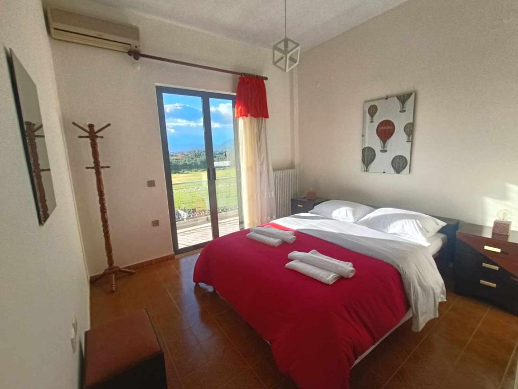 um quarto com uma cama grande com lençóis vermelhos e almofadas brancas em Nafplion Seaside em Néa Kíos