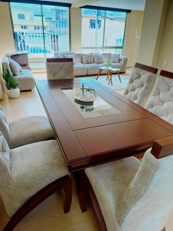 a living room with a wooden table and chairs at Amplio apartamento El Eden cerca Embajada Americana y Solca - zona tranquila seguridad 24-7 in Quito
