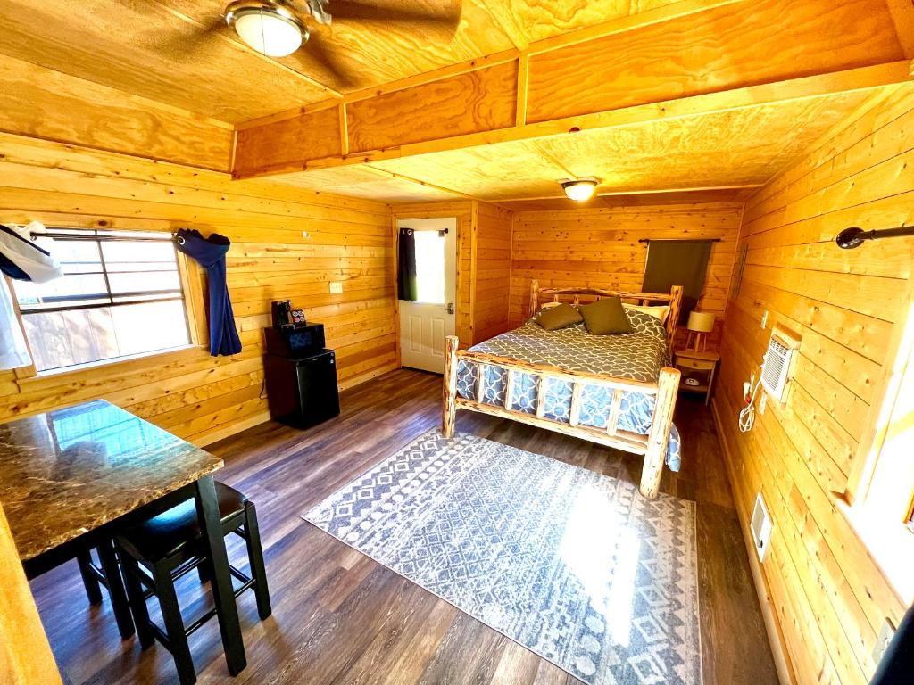 a bedroom with a bed in a wooden cabin at Triple G’s Resort - Cabin 10 in Pinnacle