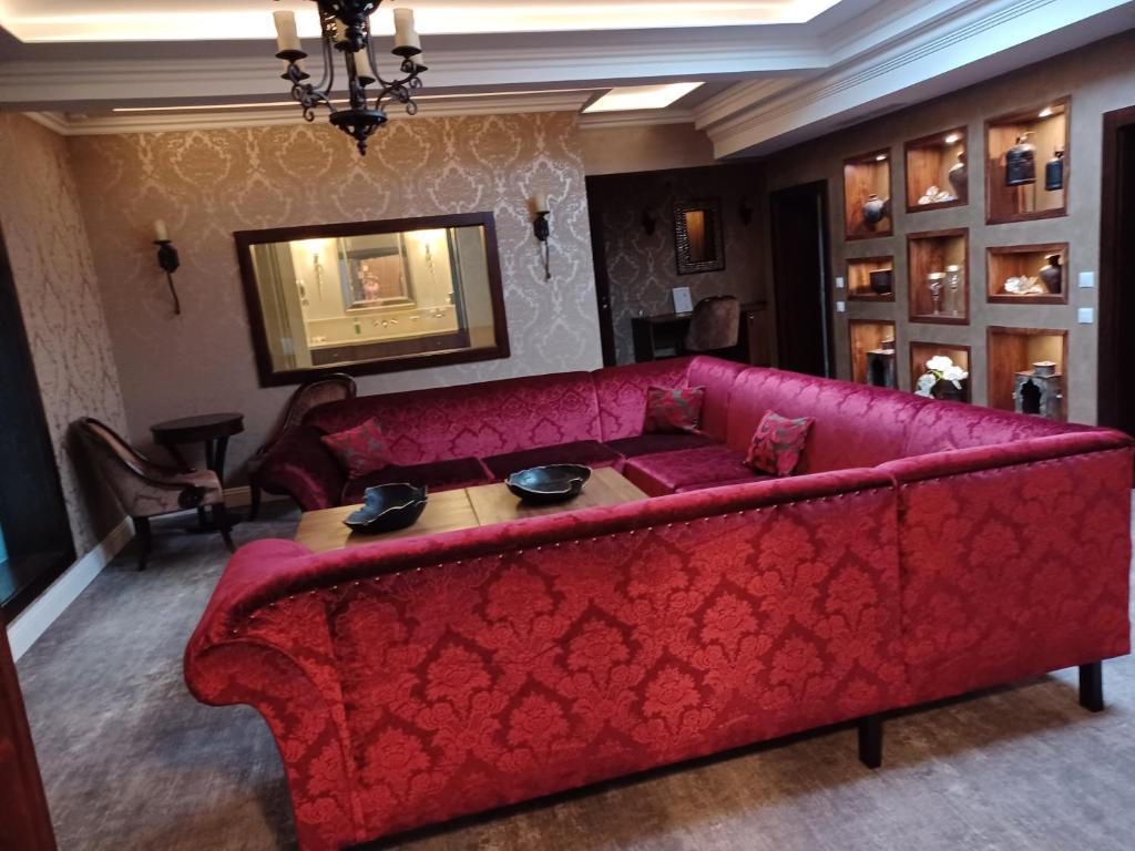 a red couch in a living room with a table at Hotel Dvorana in Karlovy Vary