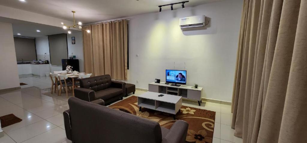 a living room with a couch and a tv and a table at AKMA HOMES DESARU in Bandar Penawar
