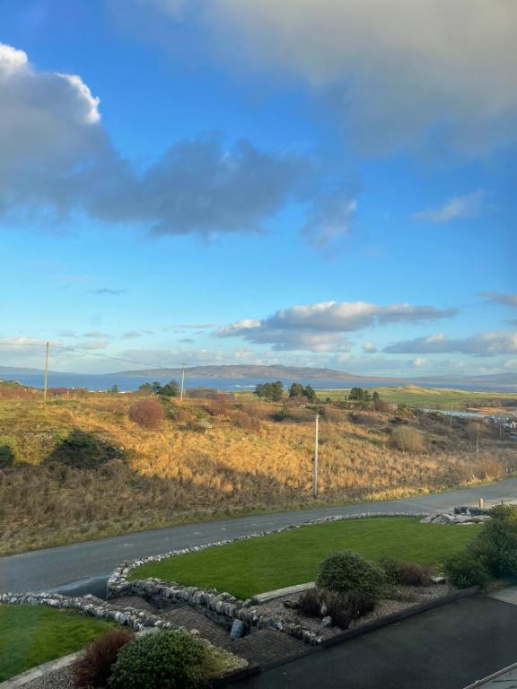 Blick auf eine Straße mit Feld und Himmel in der Unterkunft Breezy Point Guesthouse in Donegal