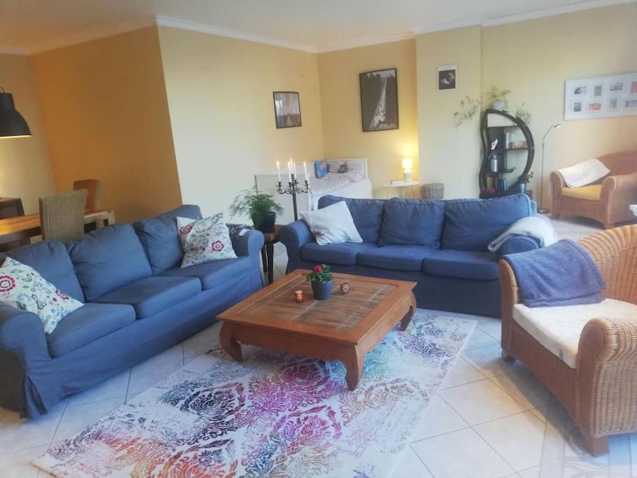 a living room with blue couches and a coffee table at Penthousewohnung 120 qm Innenstadt+ Dachterrasse in Bremen