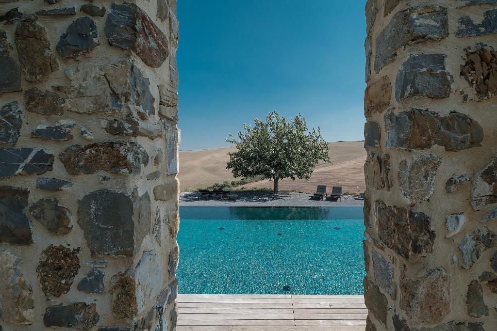 a view of a swimming pool from a stone building at Podere San Pasquale in Castiglione dʼOrcia