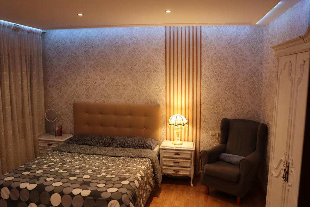 1 dormitorio con 1 cama, 1 silla y 1 lámpara en Habitación matrimonial cómoda Av Santa Ana 25 3d en Tudela