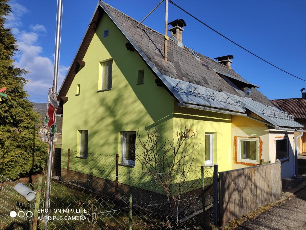 a yellow and green house with a black roof at Nice small house in beautiful Carinthia in Feistritz im Rosental