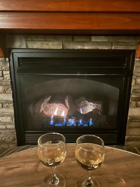 two glasses of wine on a table in front of a fireplace at Cozy 4BR Ski retreat and Water Park! in Massanutten