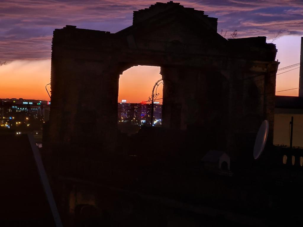un vieux bâtiment avec le coucher du soleil en arrière-plan dans l'établissement Centrum 3, à Belgrade