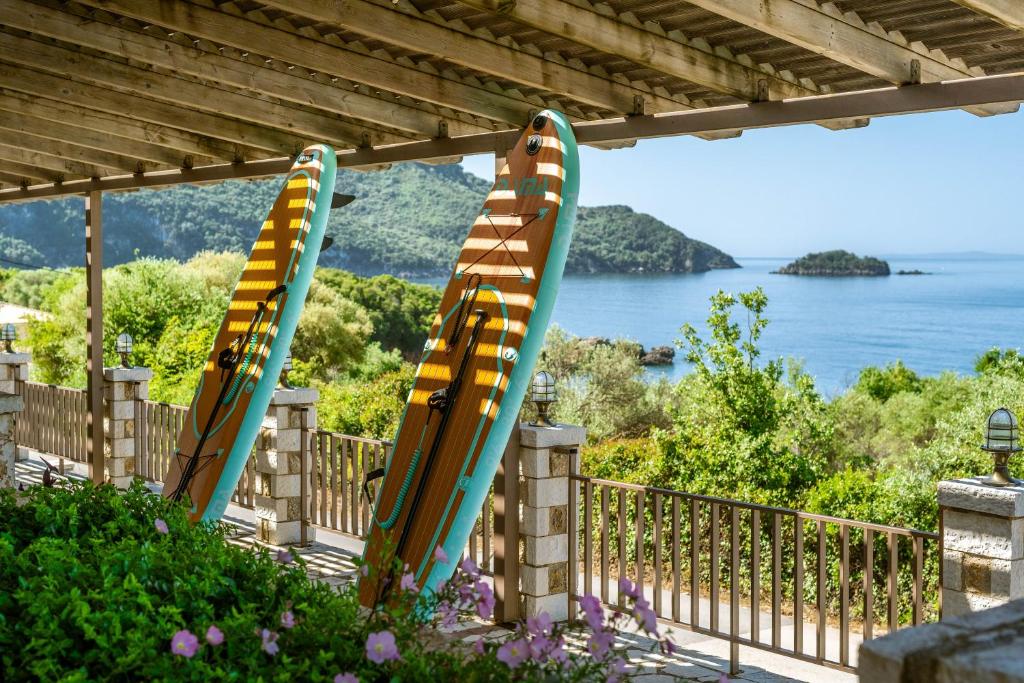 three surfboards are lined up against a fence at 3Aktes Suites & Studios in Syvota