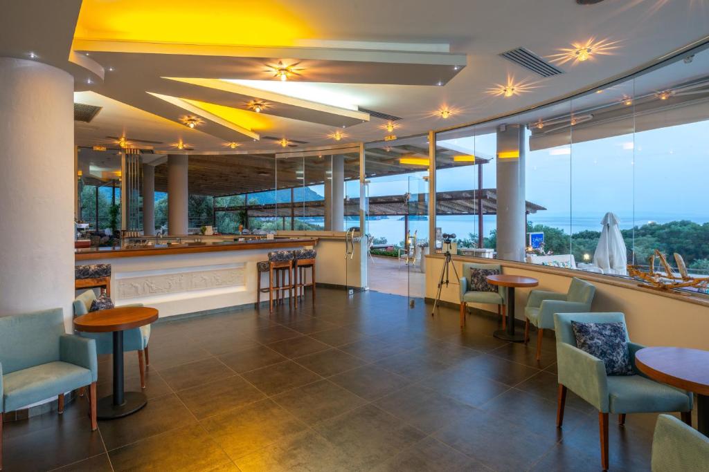 a restaurant with a bar with a view of the ocean at 3Aktes Suites & Studios in Syvota